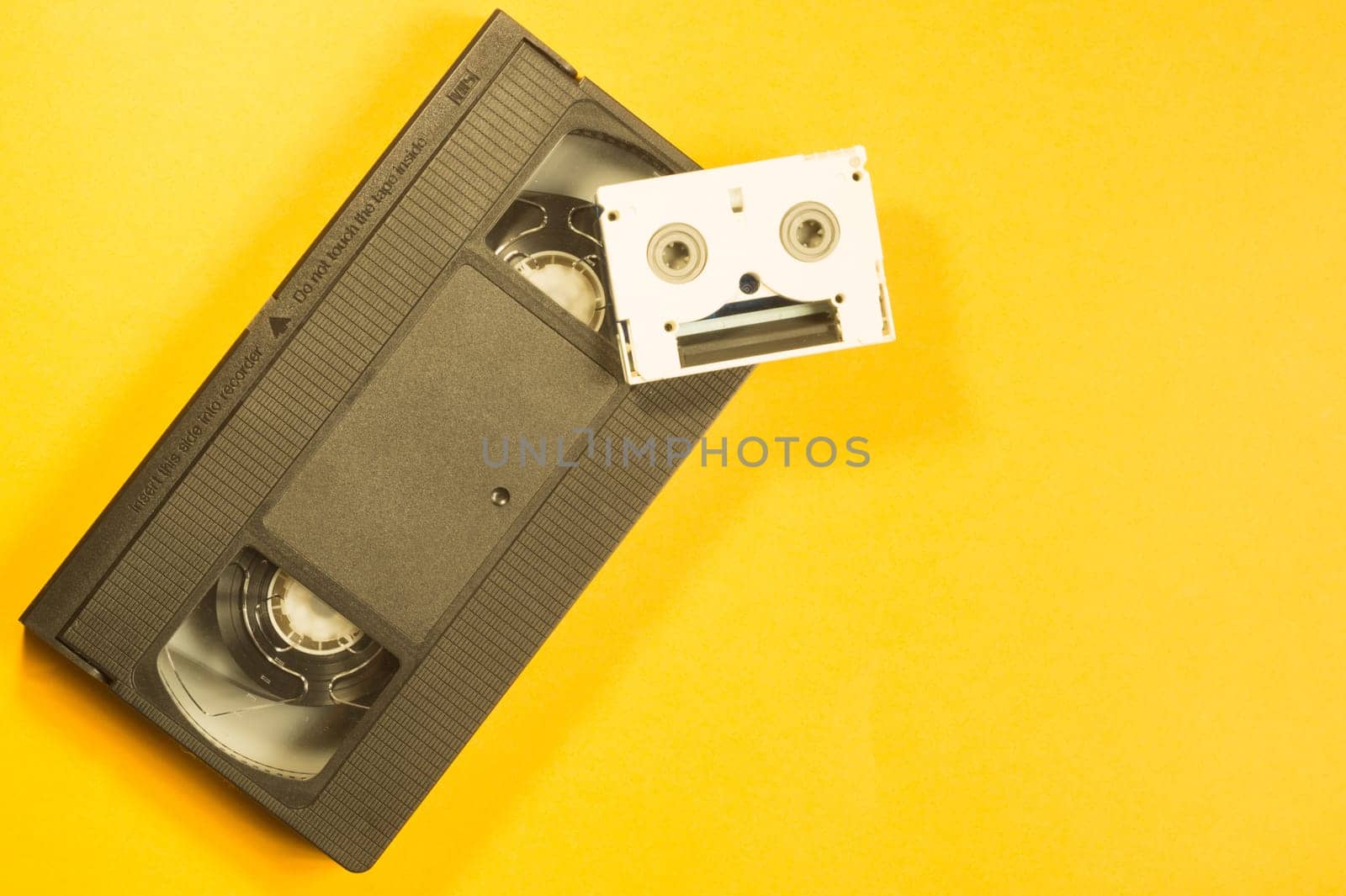 Video cassette on yellow background. mini cassette. copy space