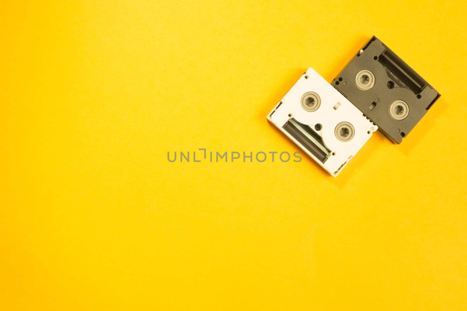 Digital video cassette on yellow background. mini cassette. copy space