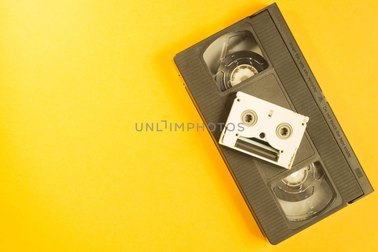 Video cassette on yellow background. mini cassette. copy space