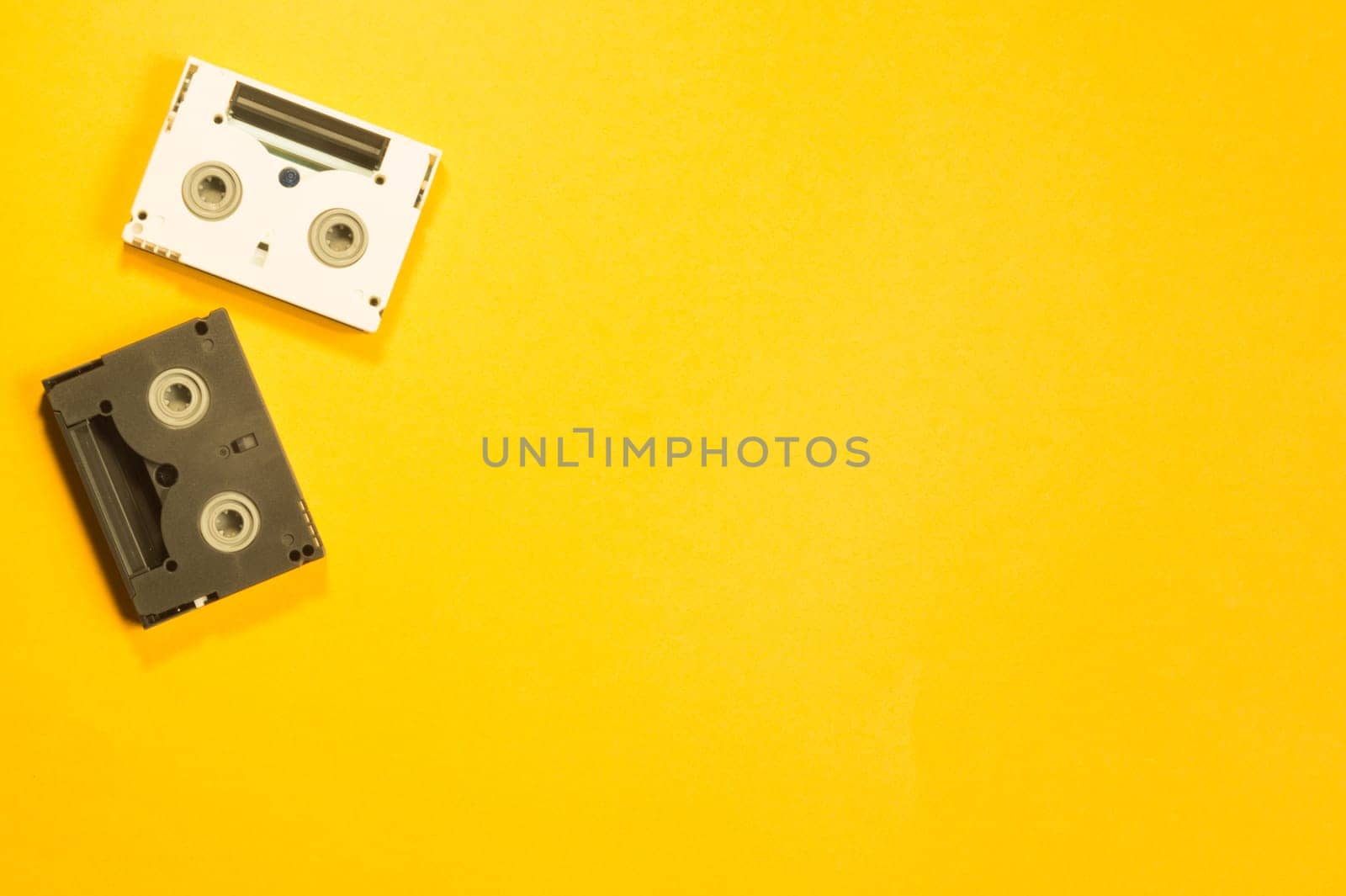 Digital video cassette on yellow background. mini cassette. copy space