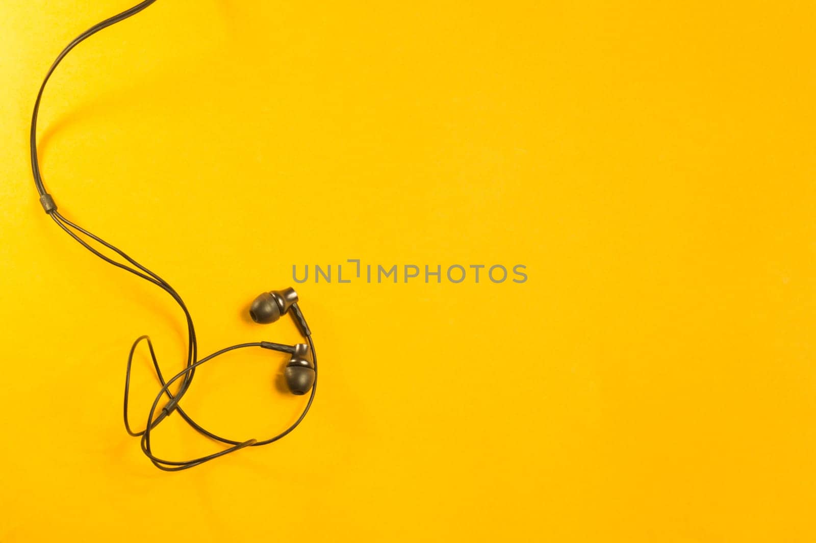 Earphones isolated on yellow background. copy space