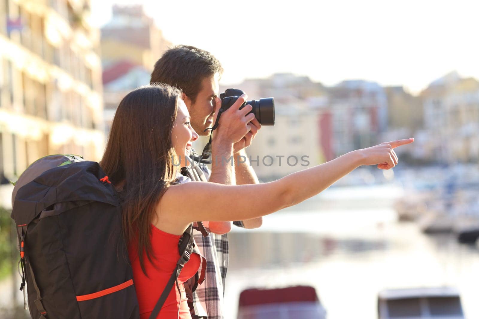 Two backpackers taking photos of landmarks on summer vacation