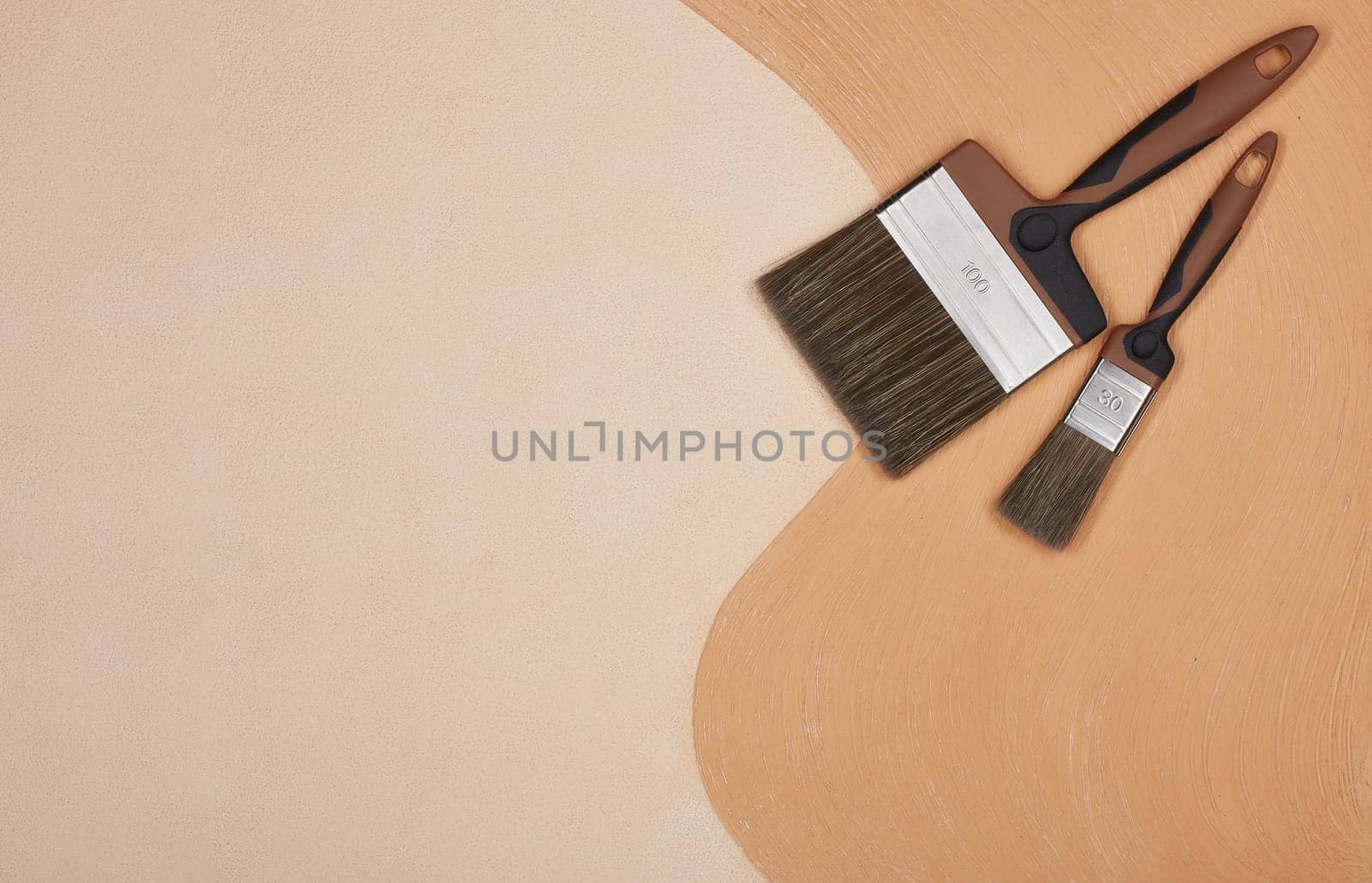 Paint brushes on textural double background consisting of two beige shades. Top view with copy space, Concept of construction or design office