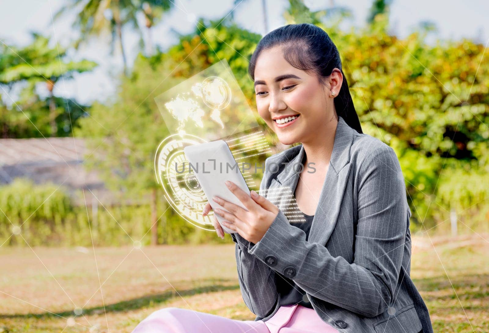 Beautiful asian business woman using digital tablet on her hand with virtual screen which display the interface of world map and binary code on the park. Digital technology concept