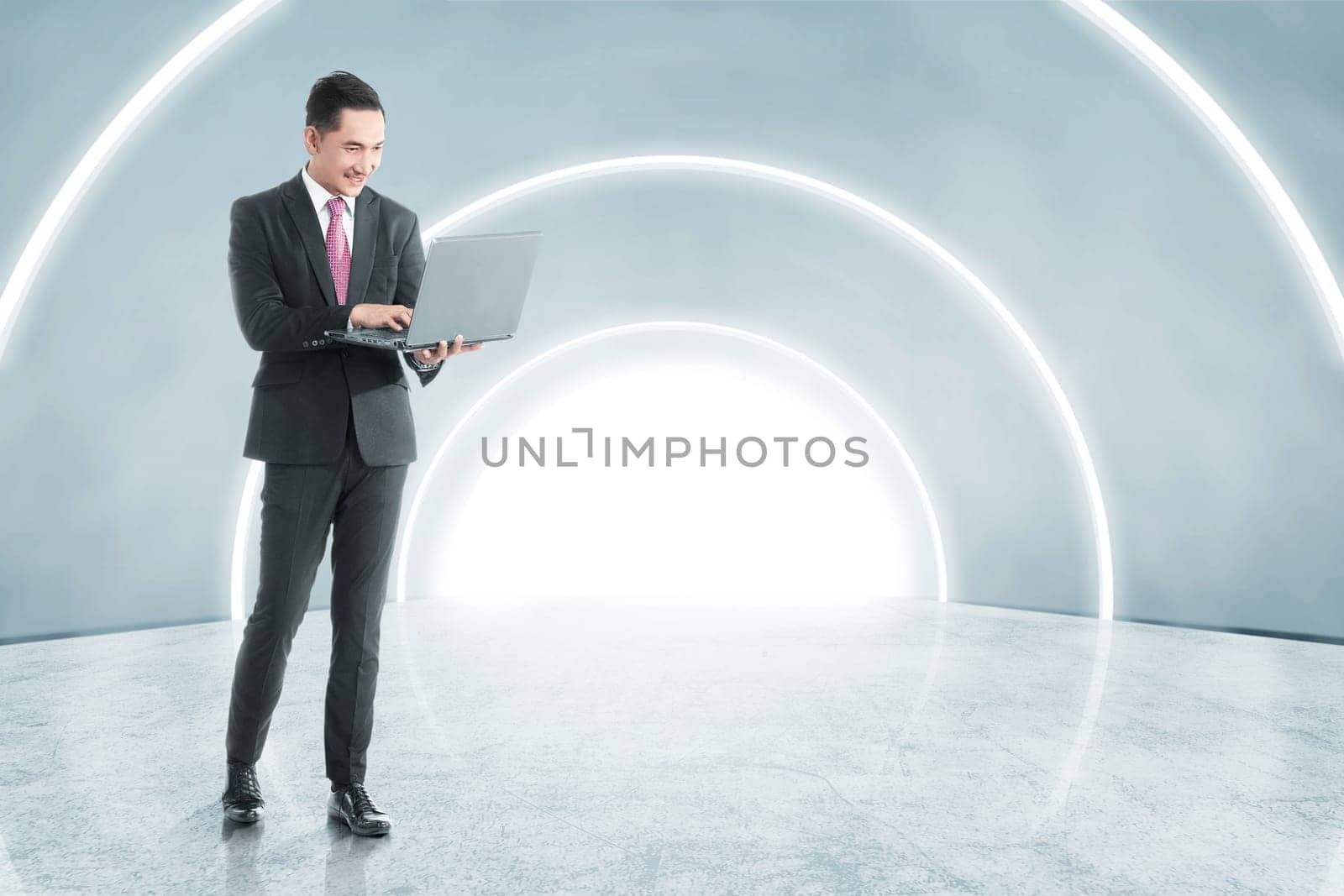 Side view of asian asian businessman holding laptop with his hand while walking on the office corridor. Future technology concept