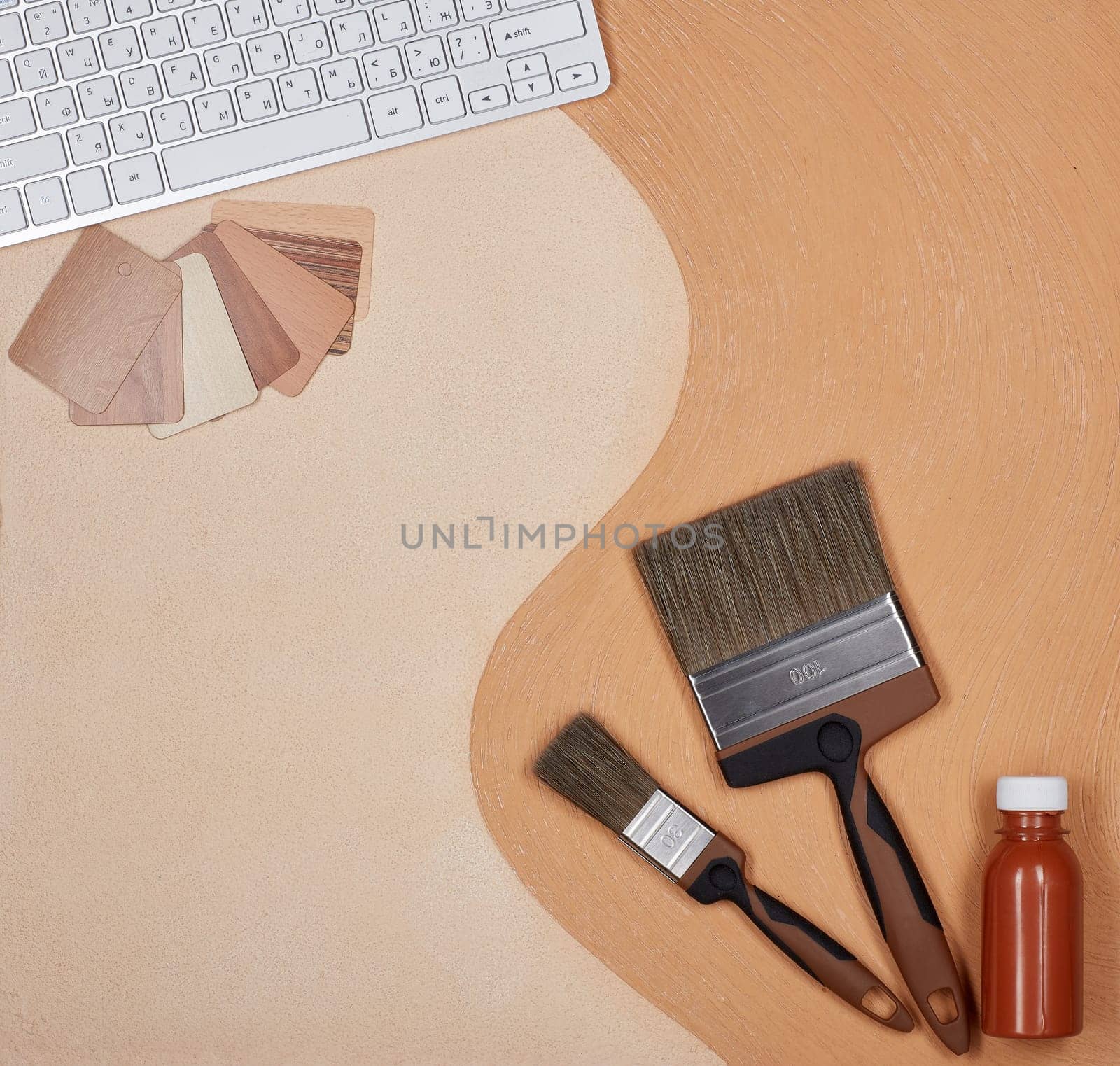 Painting accessories and computer keyboard lying on textural double background consisting of two beige shades. Top view with copy space, Concept of construction or design office. Internet shop