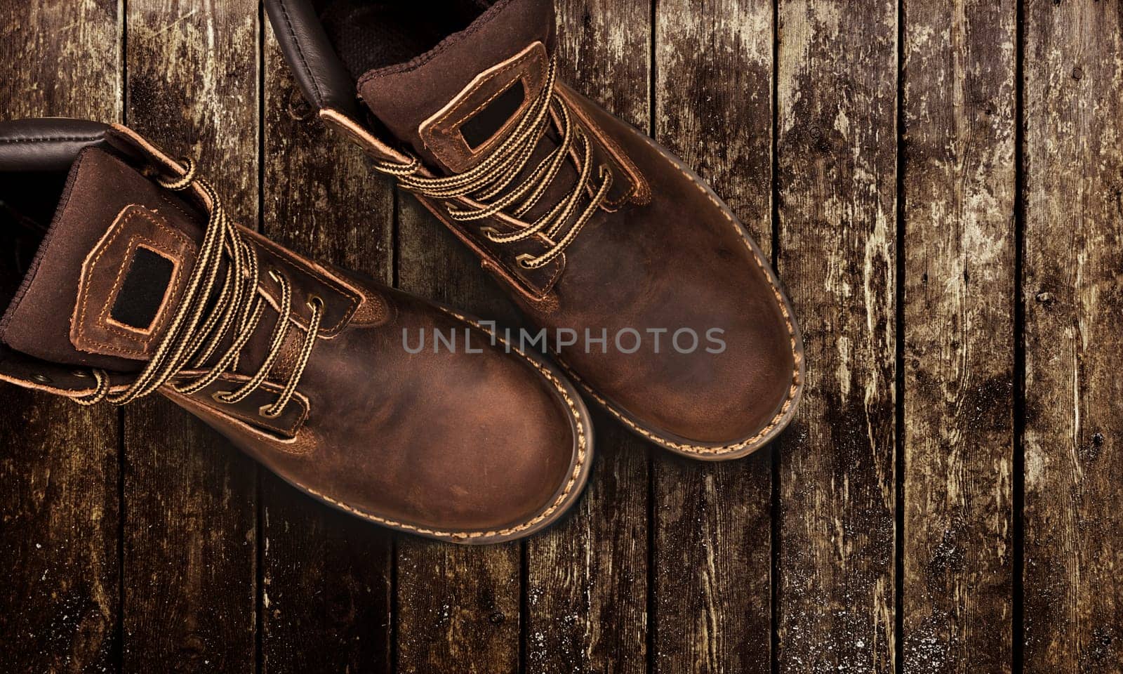 Men's brown boots on stone gravel background. Closeup isolated