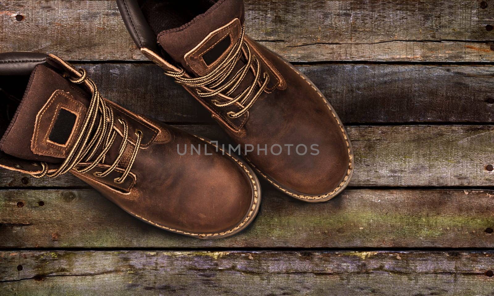 Men's brown boots on stone gravel background. Closeup isolated