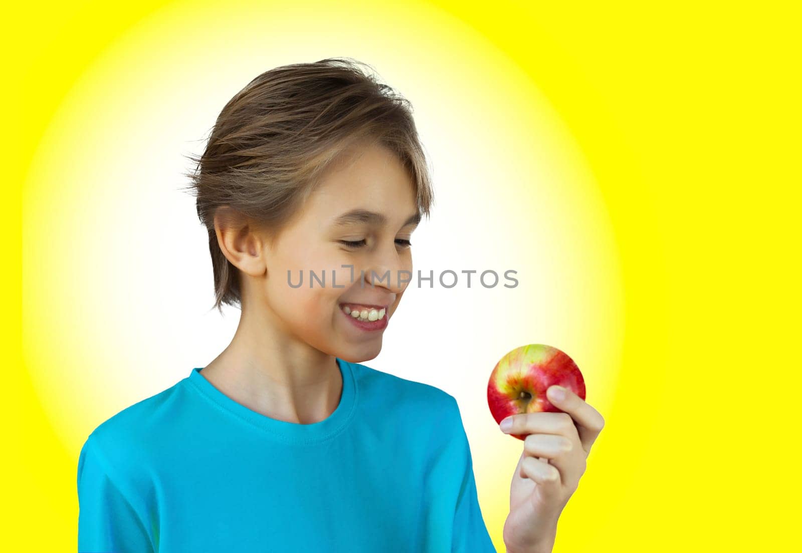 Portrait casual young man eating apple, against a white wall