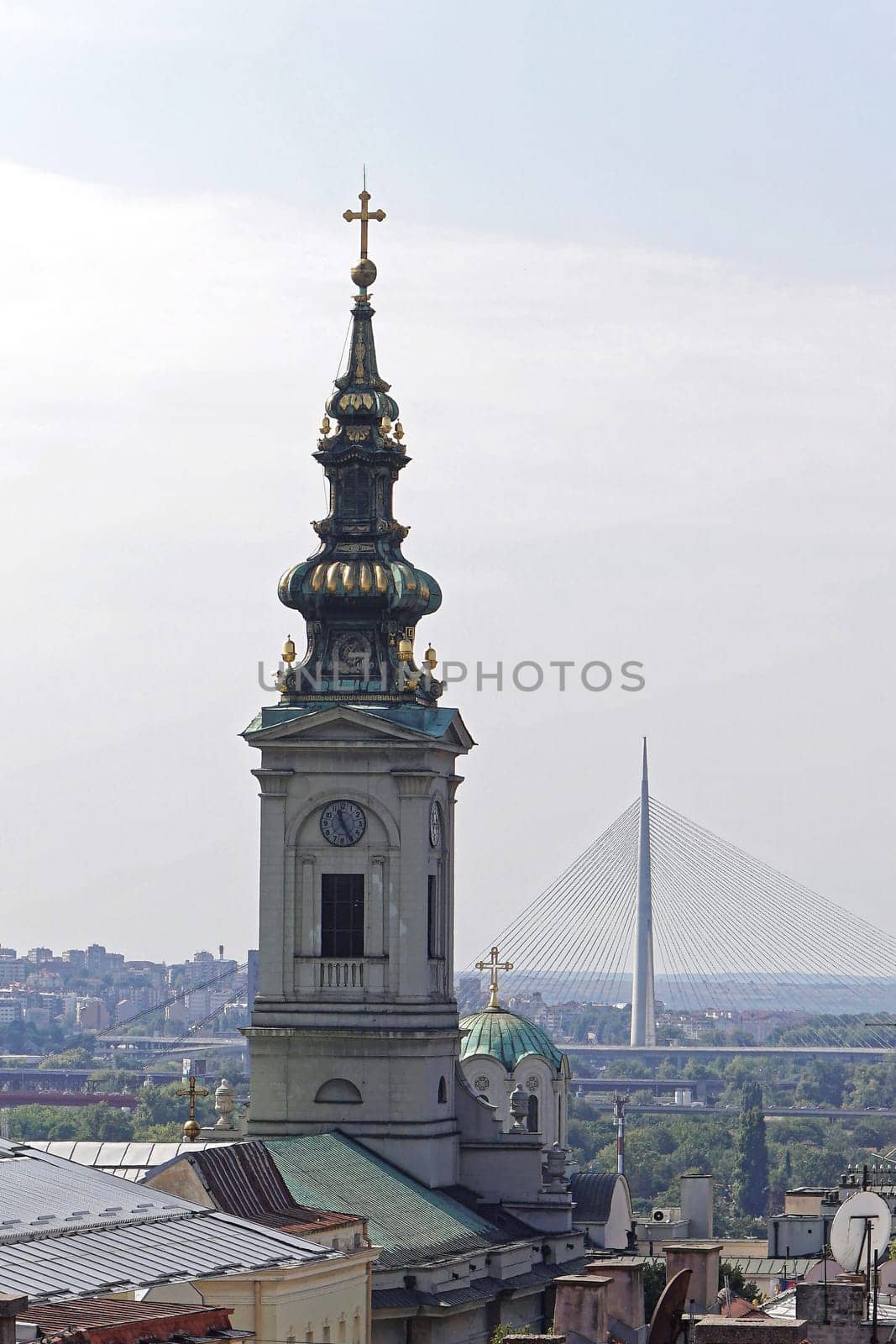 Church tower and new Ada bridge pylon in Belgrade Serbia