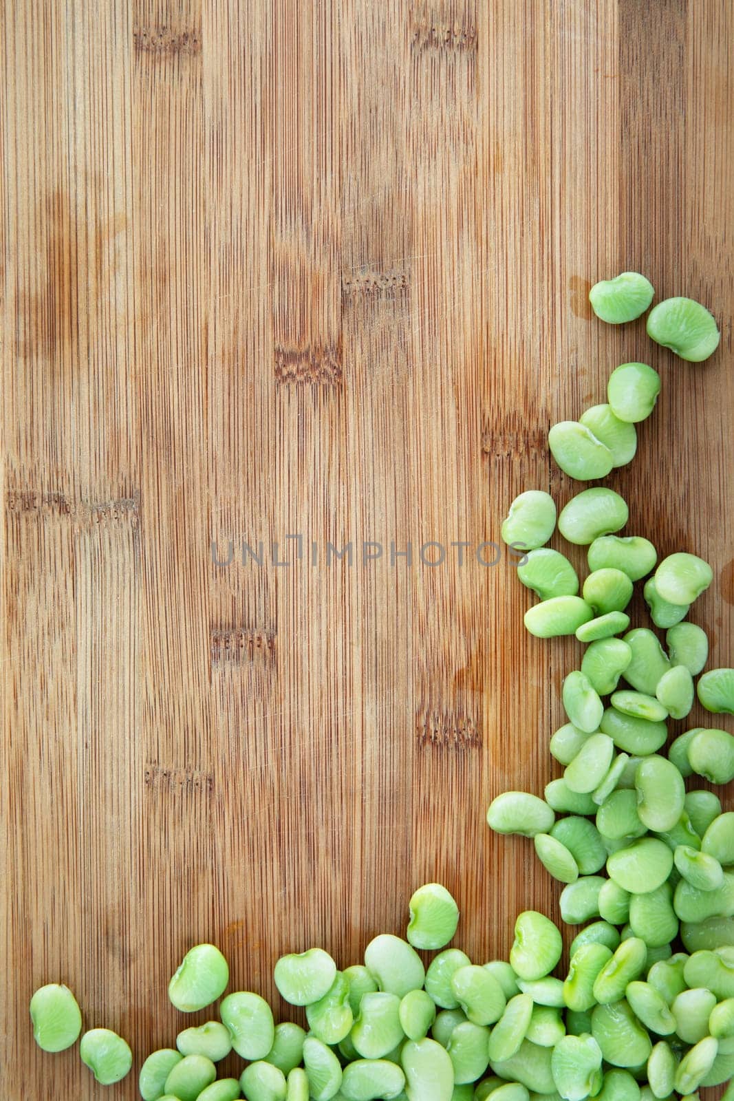 Fresh raw lima beans on cutting board with copy space.
