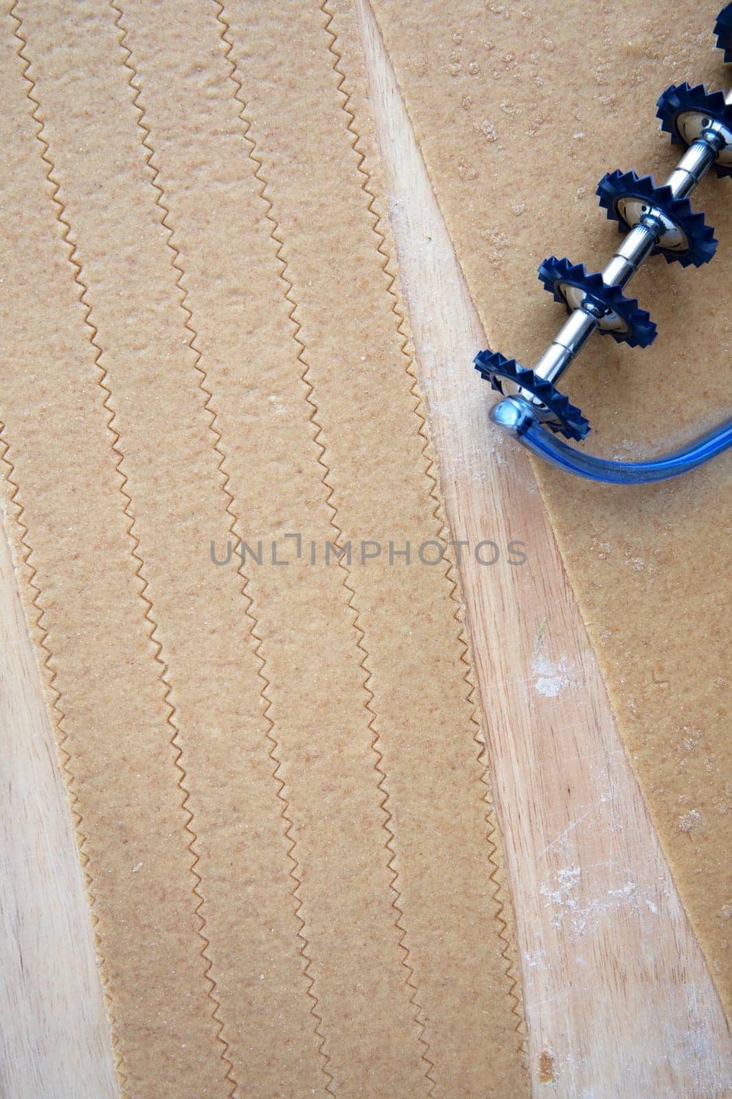 Whole wheat pasta dough on cutting board, cut into pappardelle.