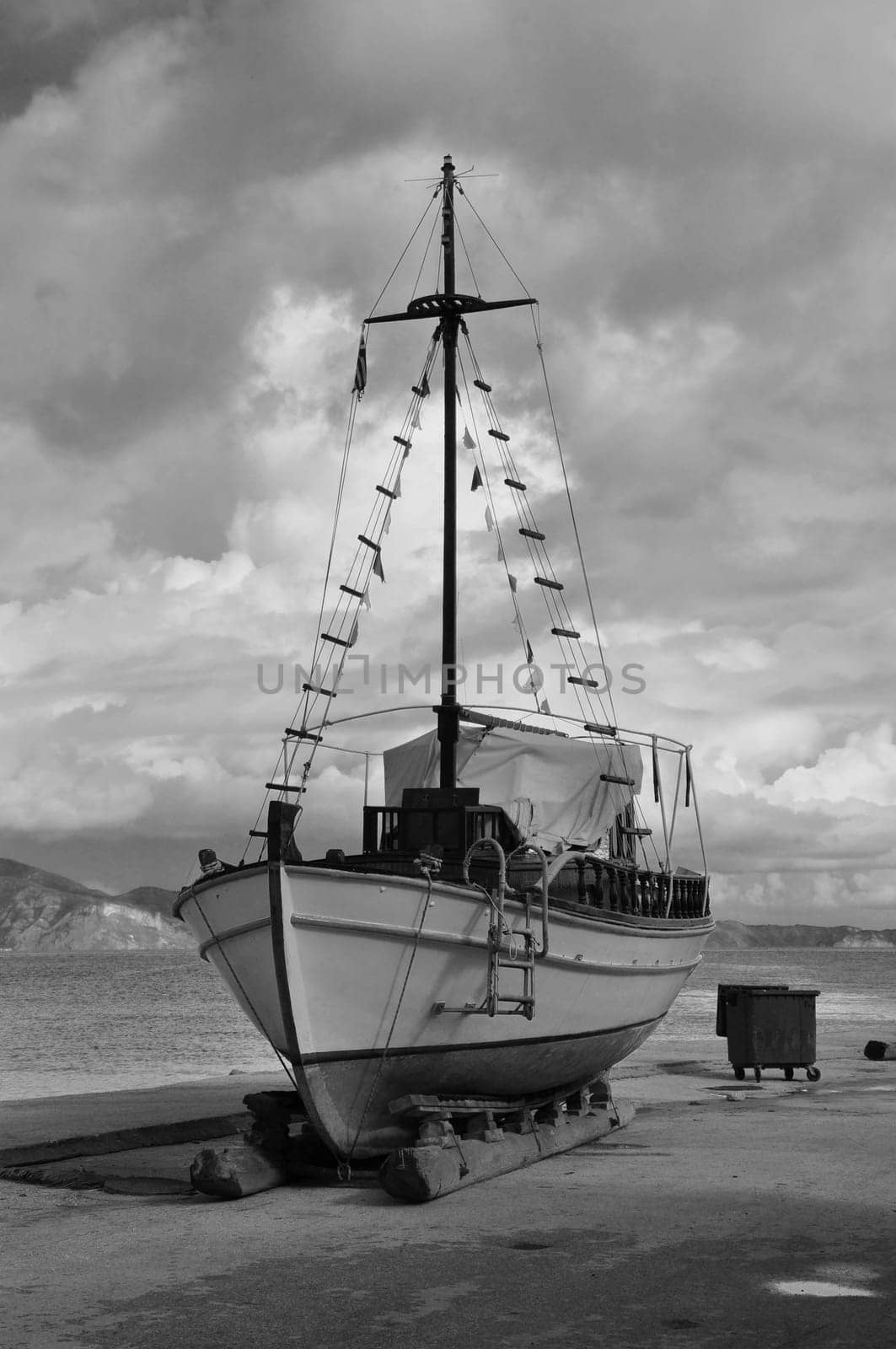 Old wooden fishing boat on shore for repair. Black and white.
