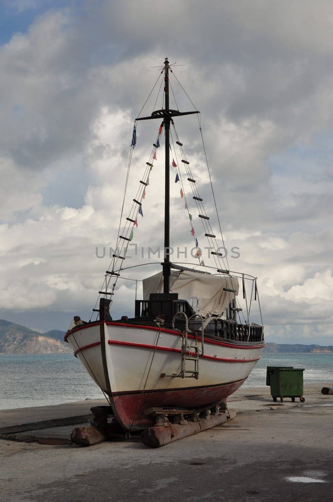Old wooden fishing boat on shore for repair.