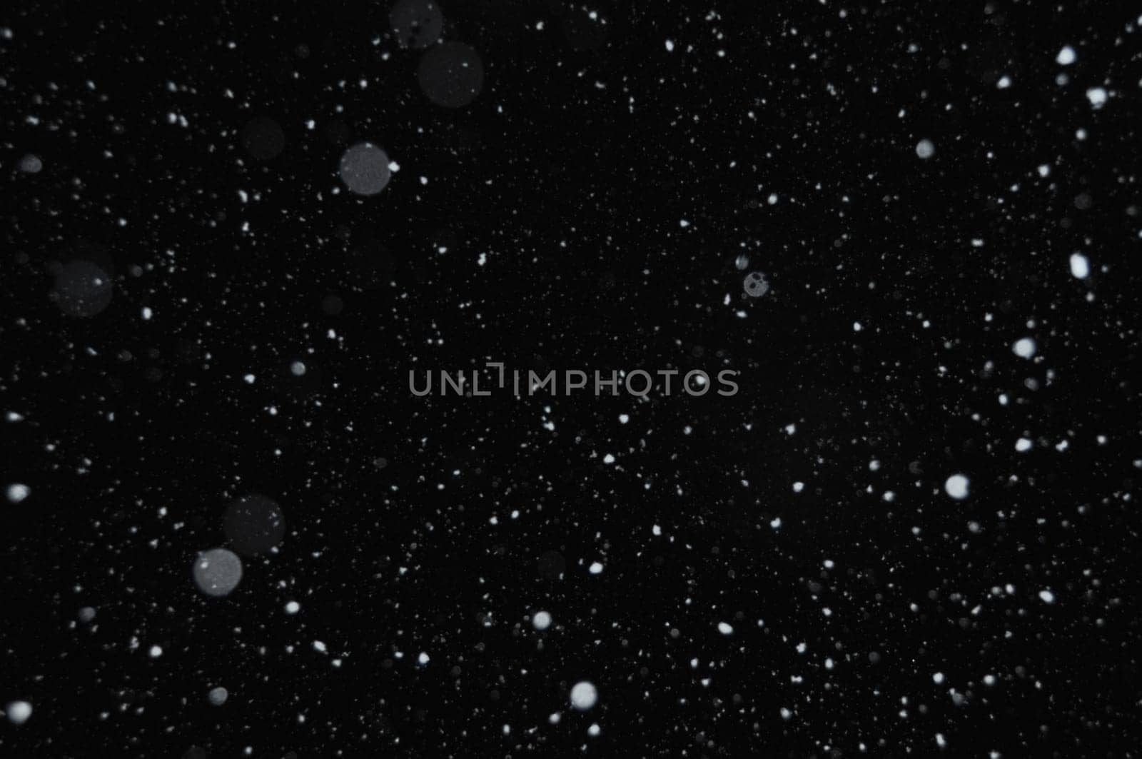 Snowflakes on winter sky. Snow storm abstract background blur.