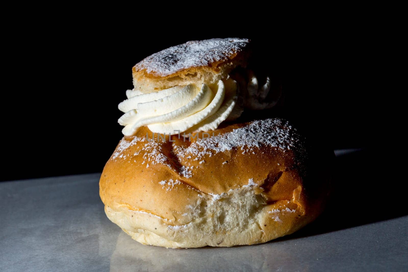 Swedish Lenten Bun (Semla) Close up with black background.