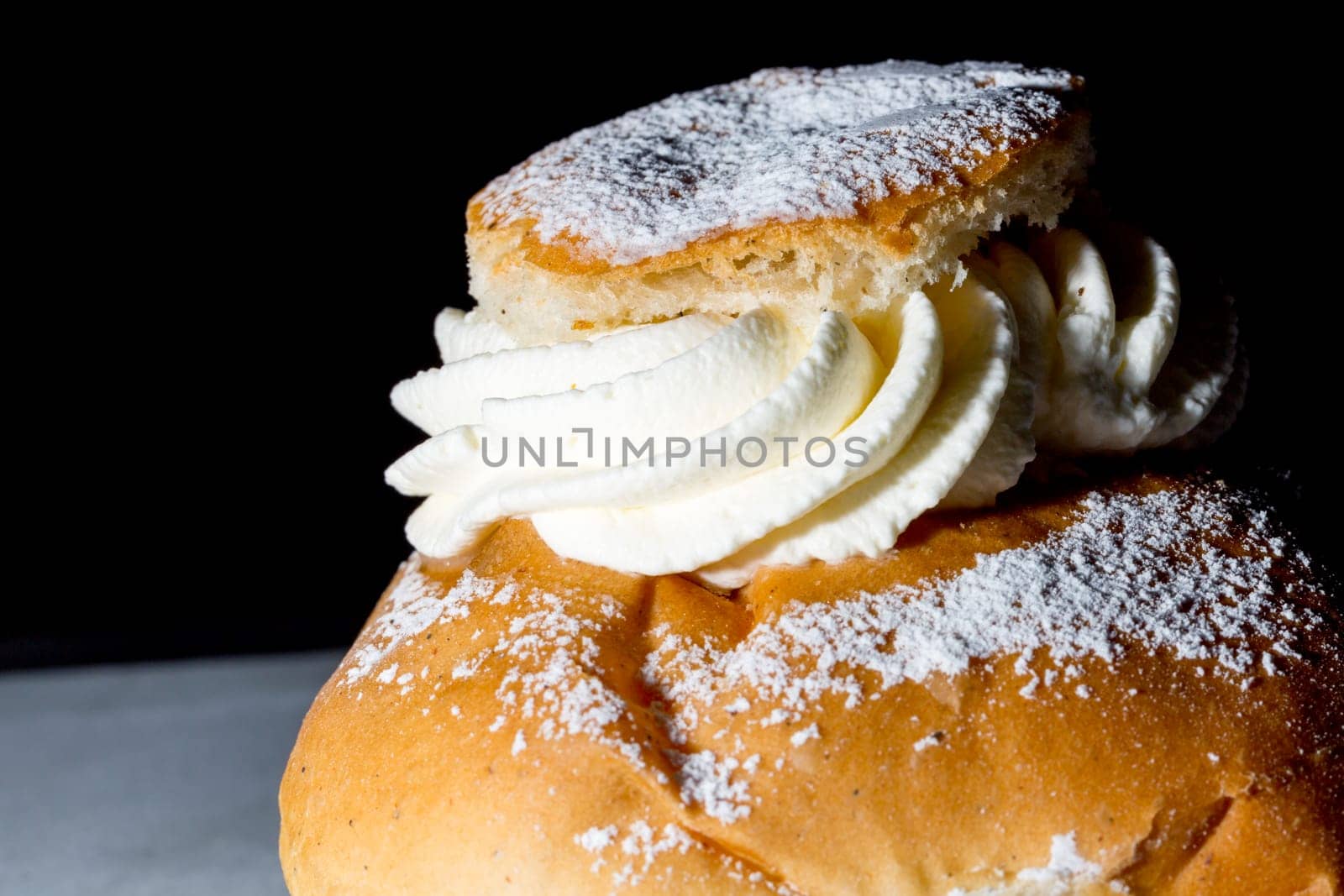 Swedish Lenten Bun (Semla) Close up with black background.