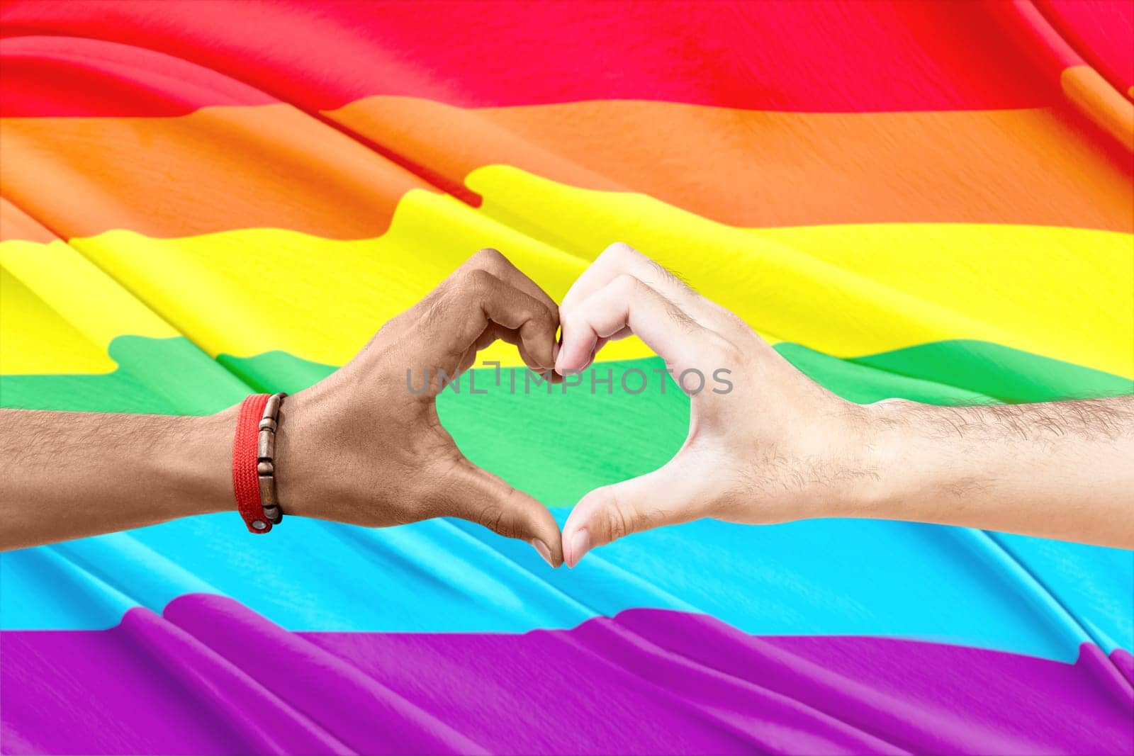 Couple of gay making a heart sign by hand with rainbow flag background. LGBT concept
