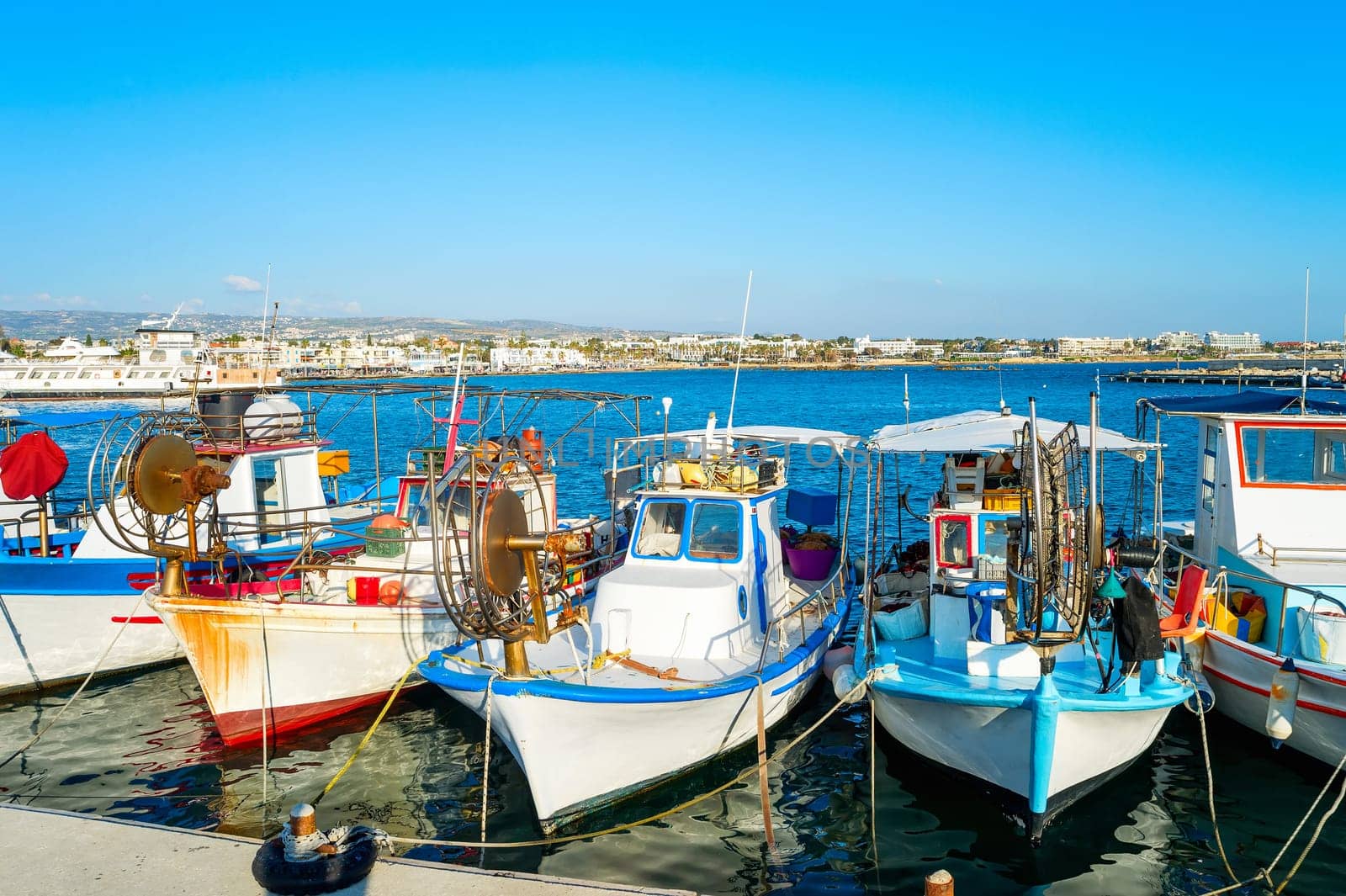 Typical colorful fishing boats moored in Paphos city harbor, sunlight, Cyprus