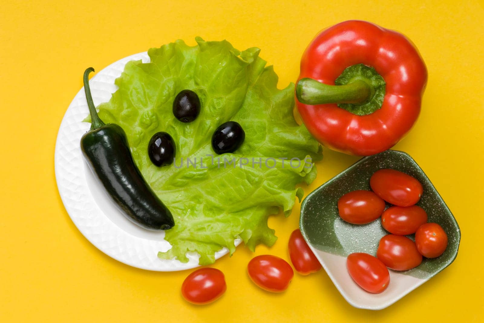 still life of jalapeno pepper,  bell pepper, tomato cherry, lettuce on yellow background