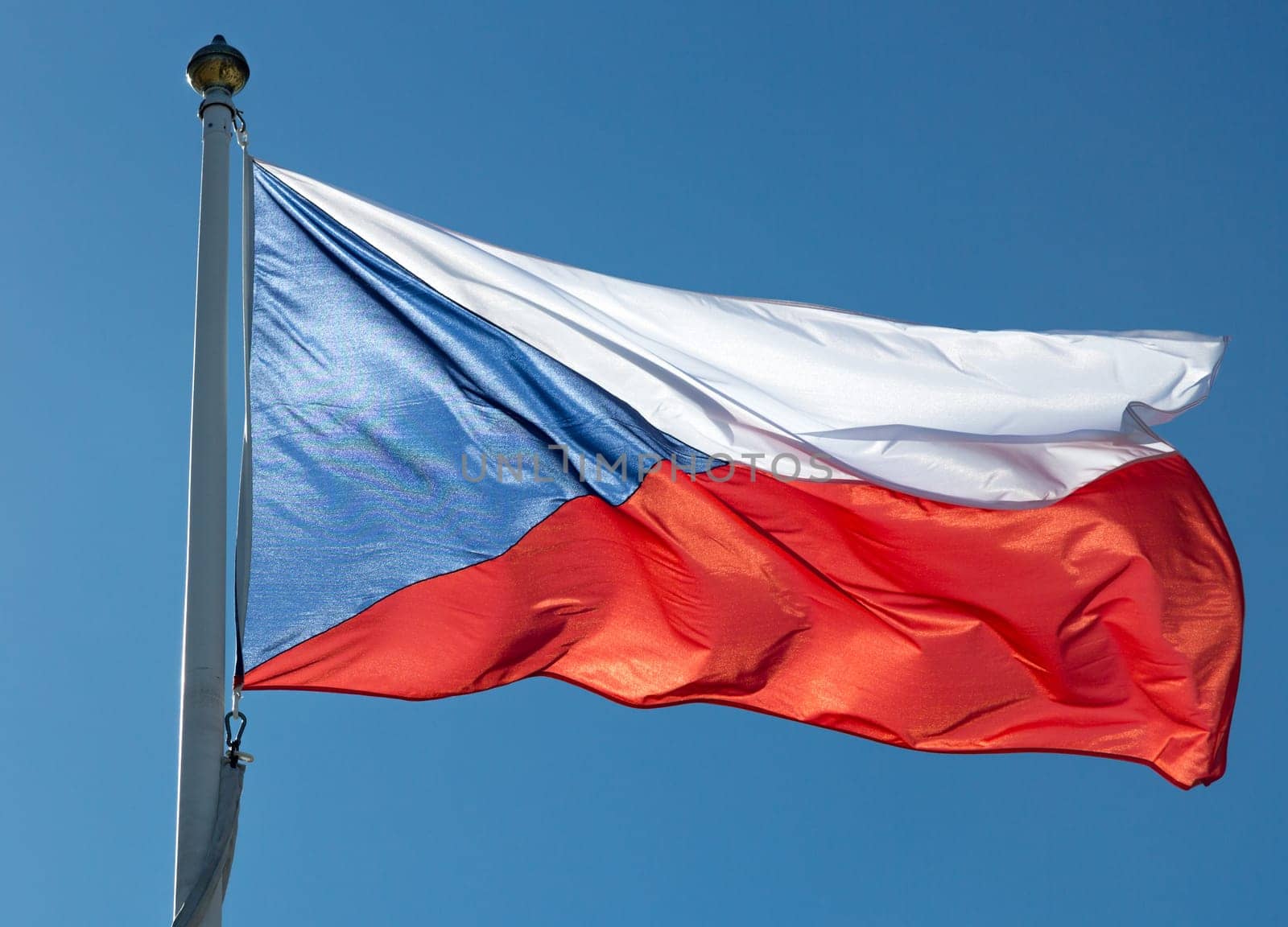Flag of the Czech Republic close up with a clear blue sky.