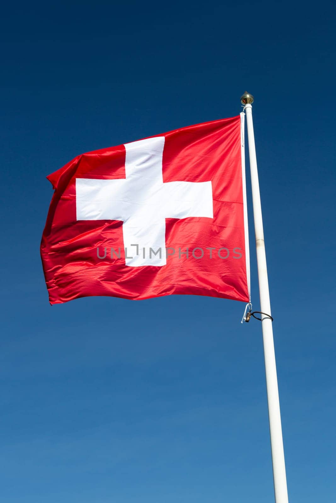 The Flag of Switzerland with a blue sky.