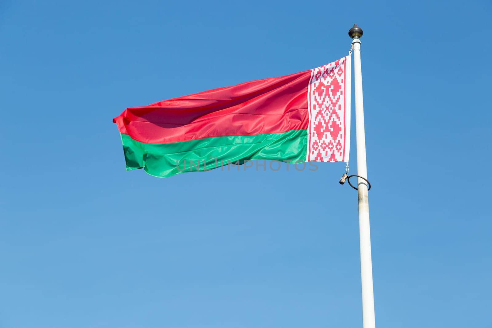 The Flag of Belarus close up with a blue sky.