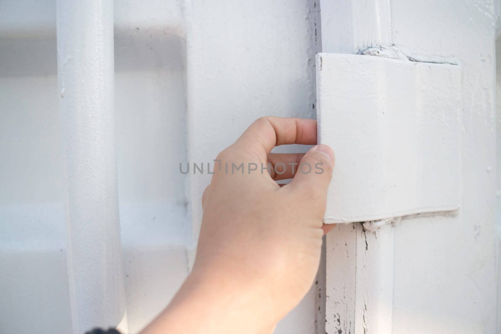 Hand on cargo container door, stock photo