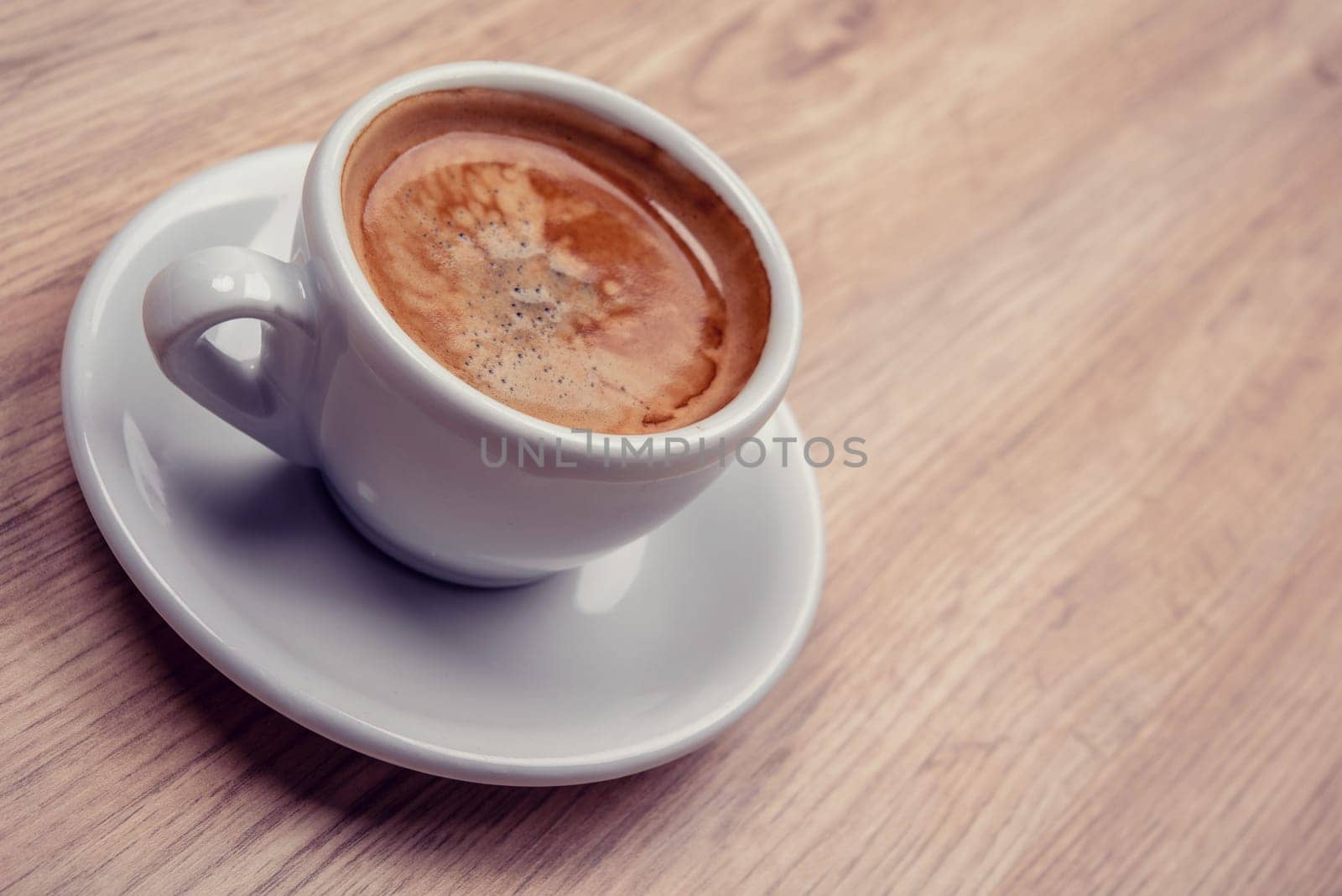 cup of coffee on wooden table from above