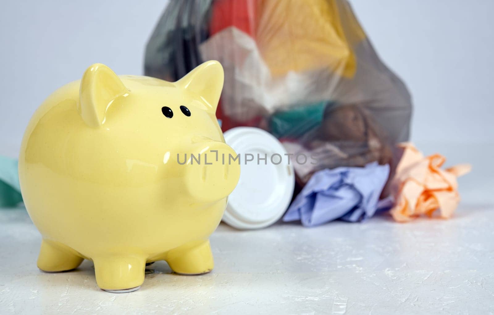 garbage bag with defferent content with yellow piggy bank