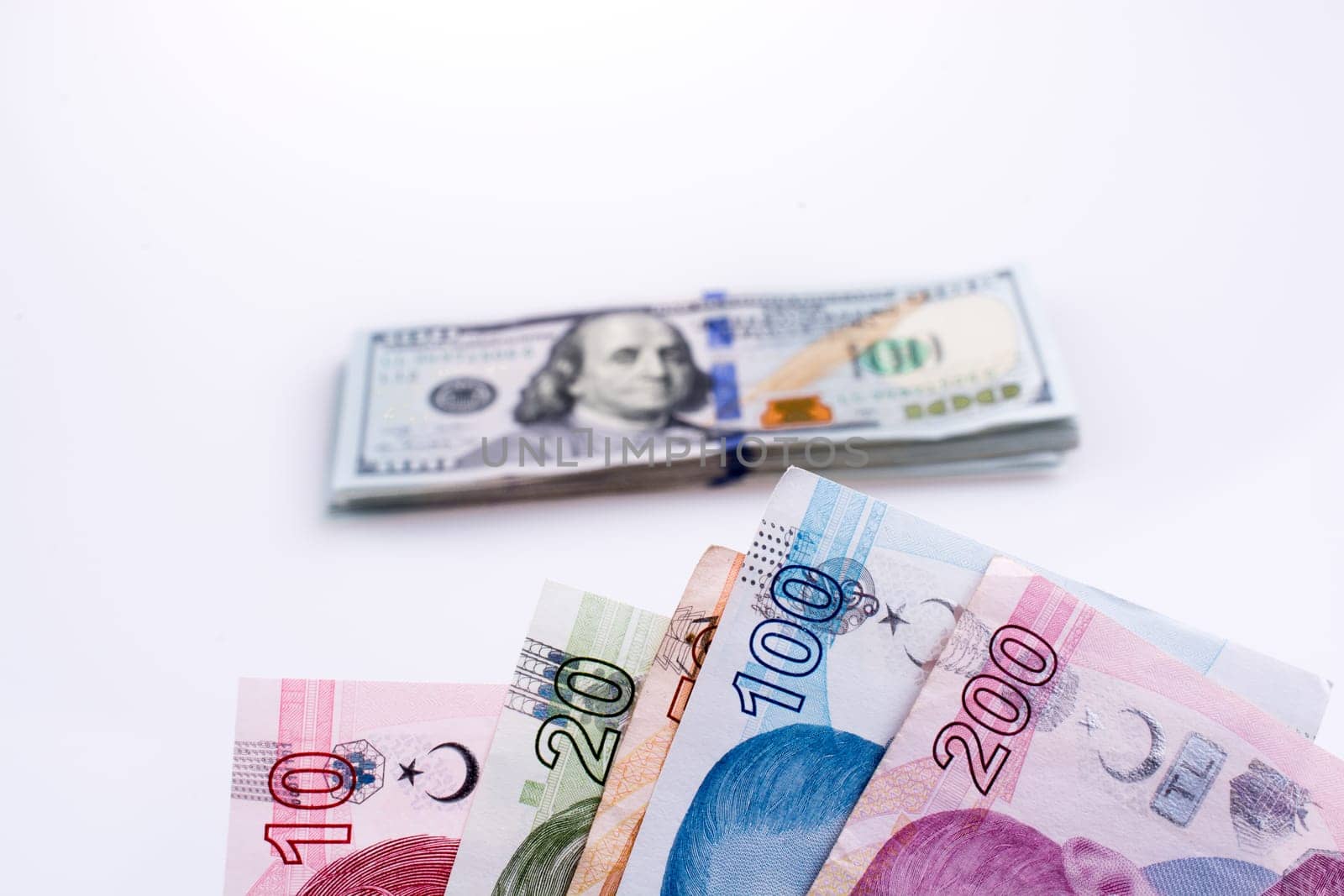 American dollar banknotes and Turksh Lira banknotes side by side on white background