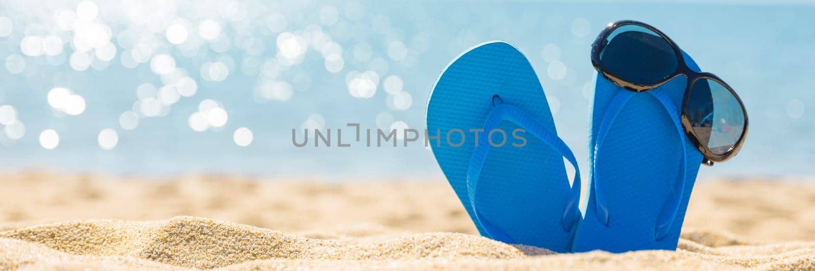 flip flops with sun glasses on the sandy tropical beach