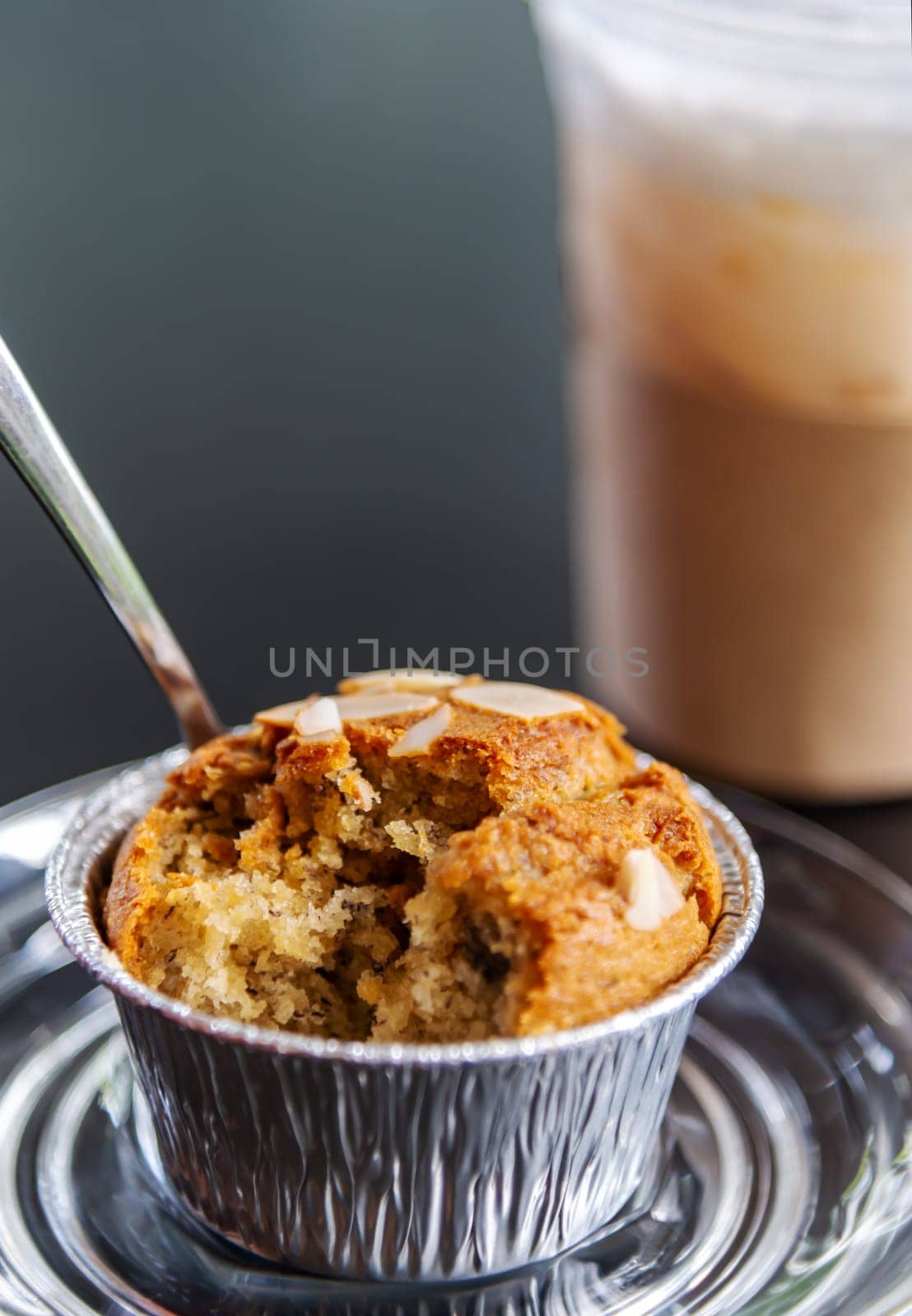 Banana cupcake with ice milk tea and water drink blurred background