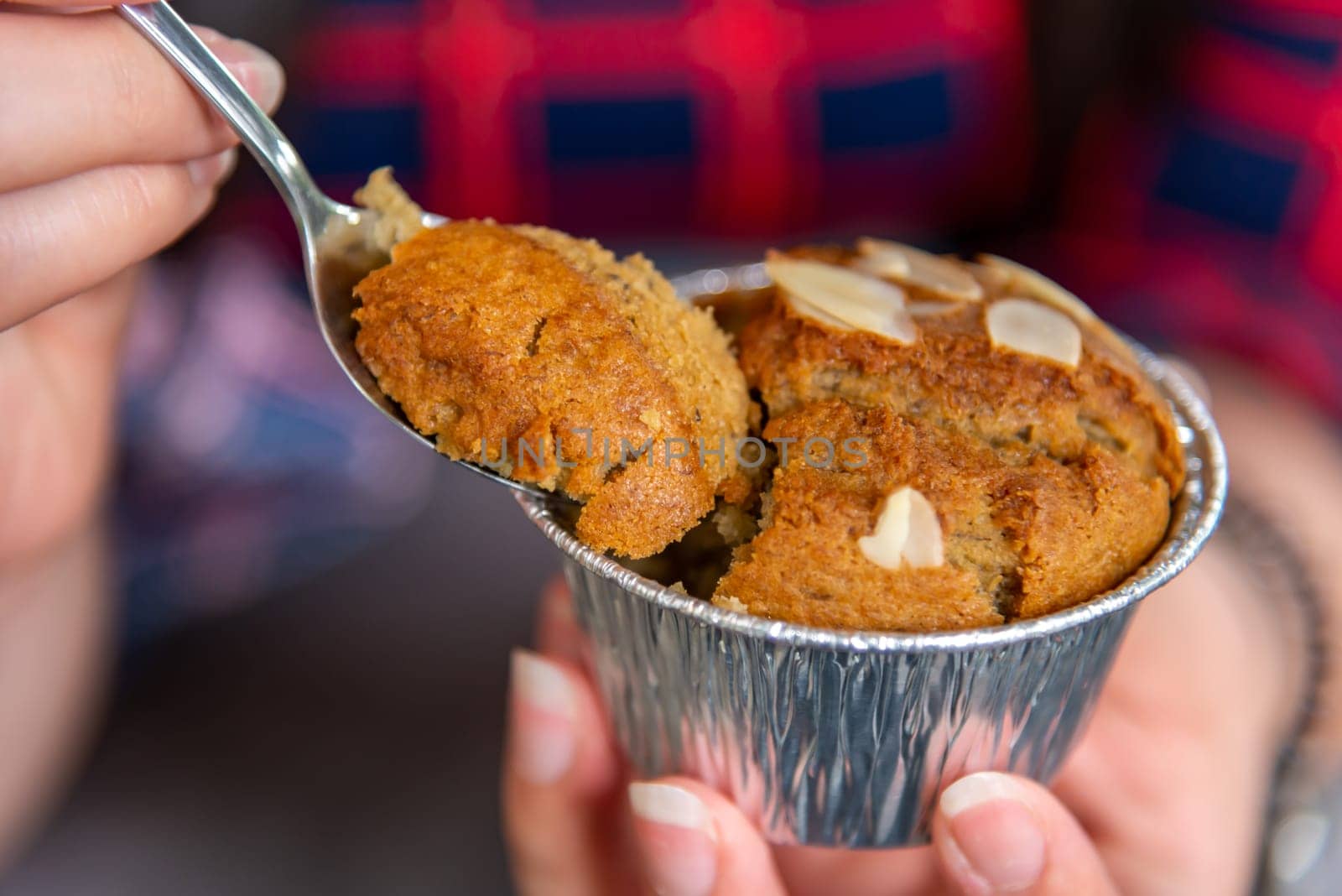 Hand women with banana cupcake in spoon on blurred background