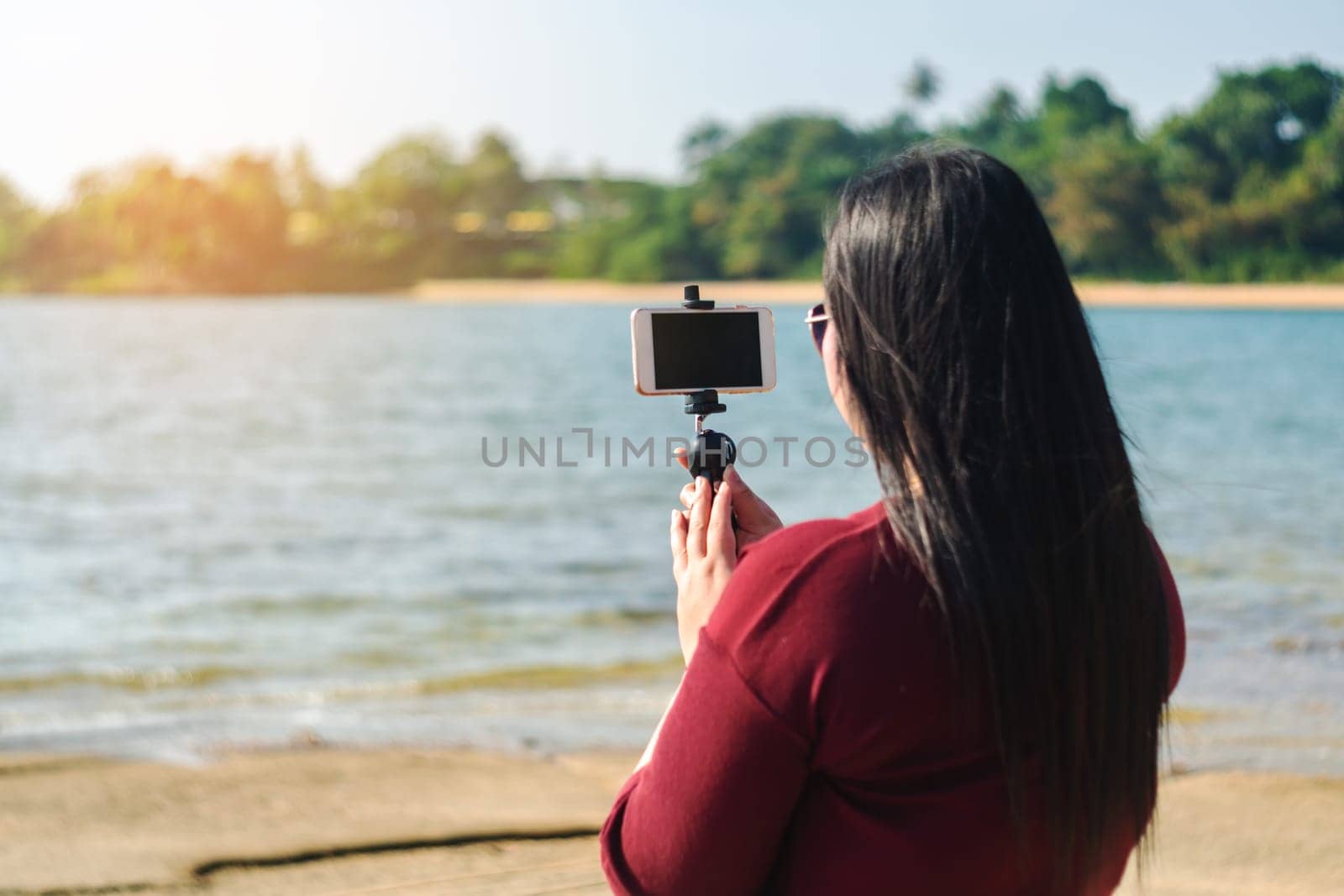 Social network and photography concept, Women with smart phone mobile in seascape nature background