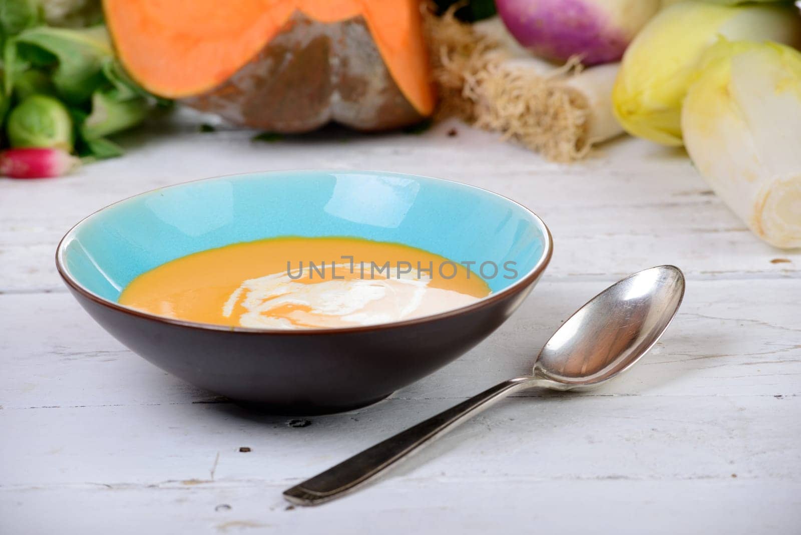 plate of pumpkin soup with  several vegetables