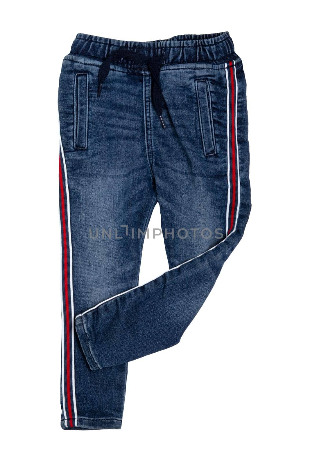 Fashionable denim clothes. Trendy stretch blue jeans trousers with lateral red stripes isolated on a white background. Fashionable jeans for child boy.