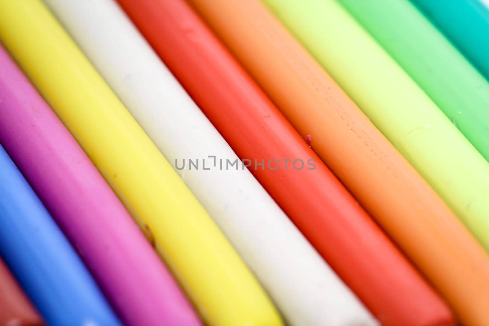 colorful children play dough lies in a row next to each other