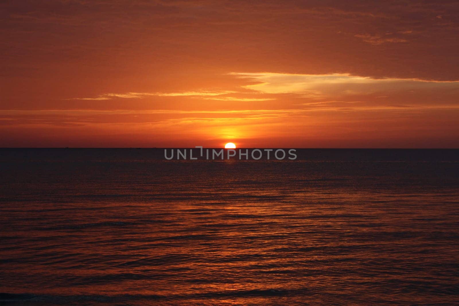 A red and yellow sunset over the ocean in Thailand
