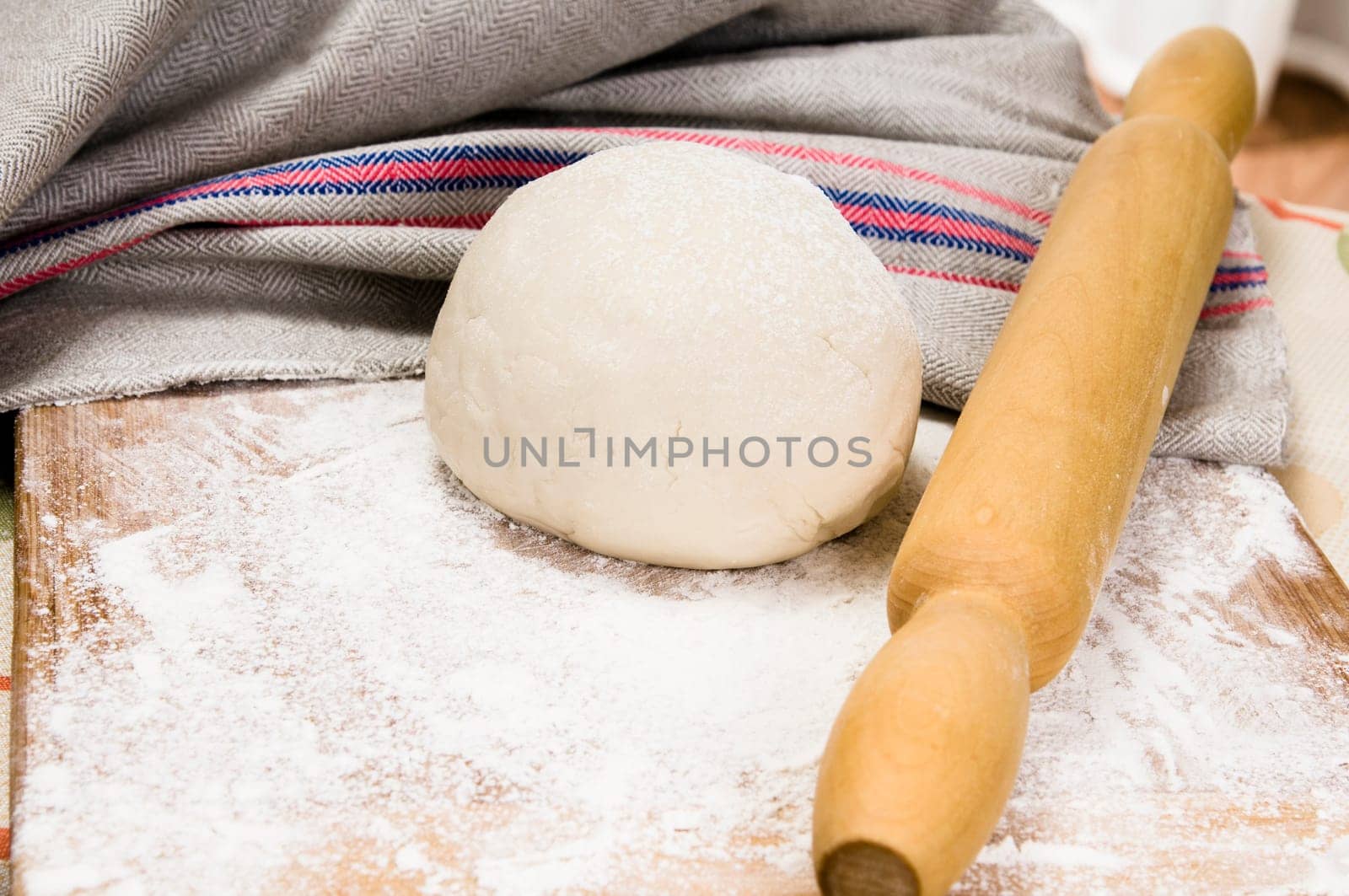 fresh raw dough and rolling pin for baking