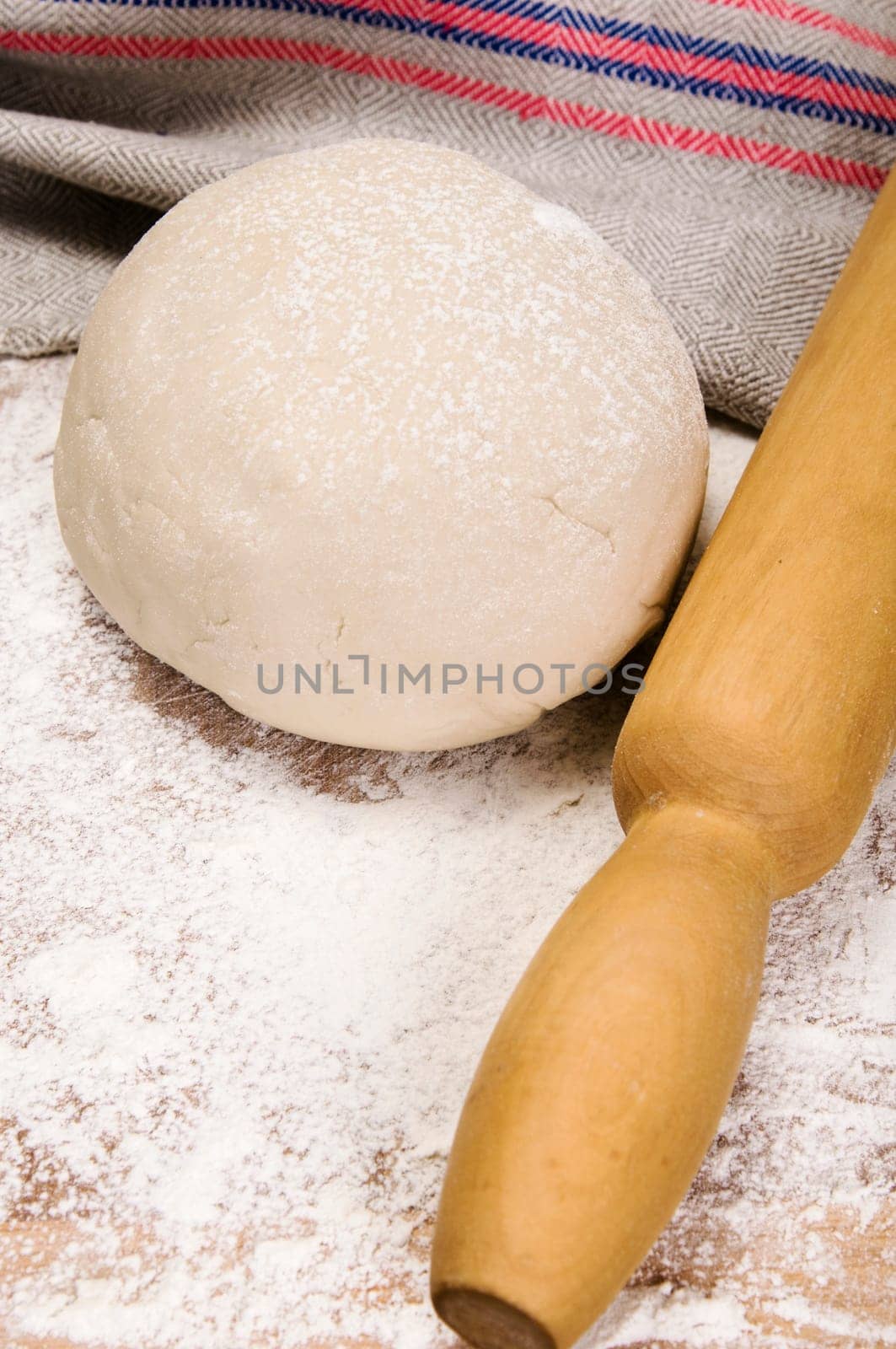 fresh raw dough and rolling pin for baking
