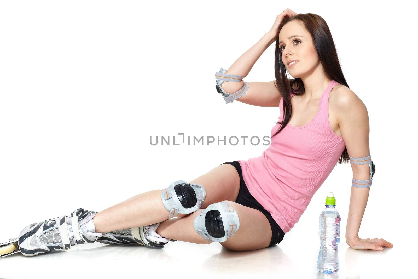 The beautiful young woman in rollerskates on a white background.