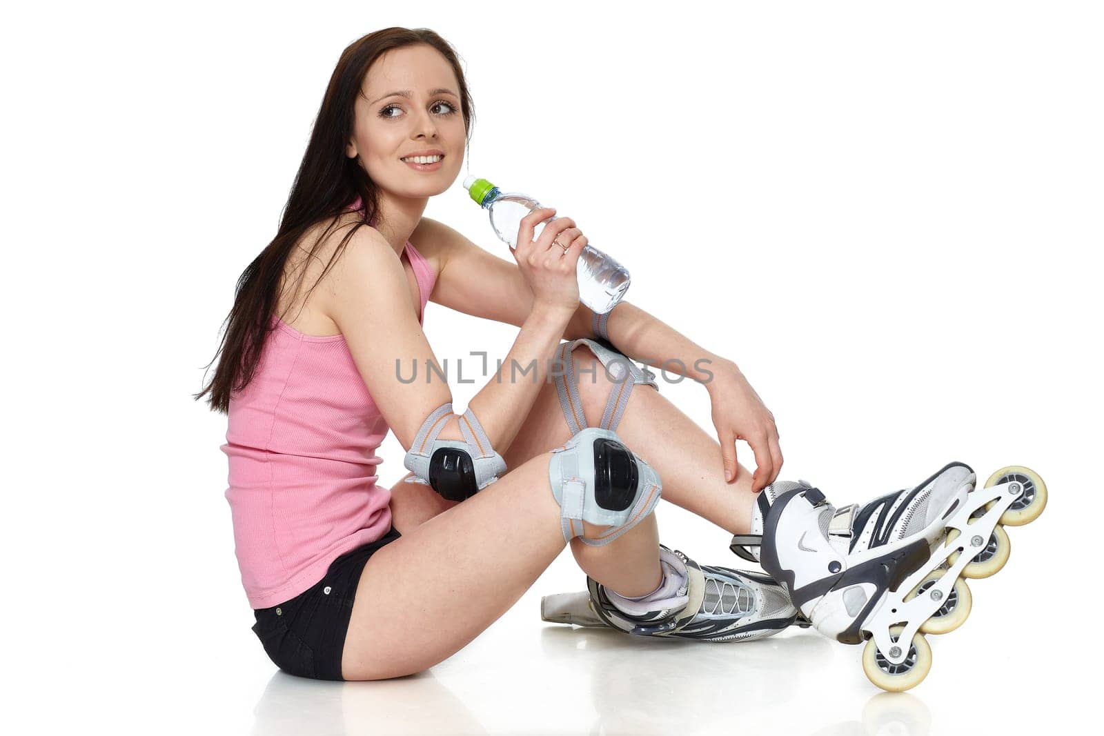 The beautiful young woman in rollerskates on a white background.