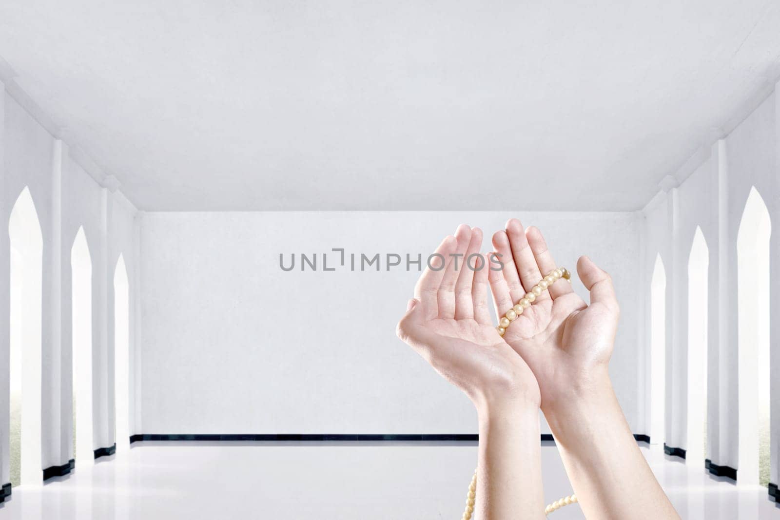 Muslim hands praying with prayer beads in the mosque