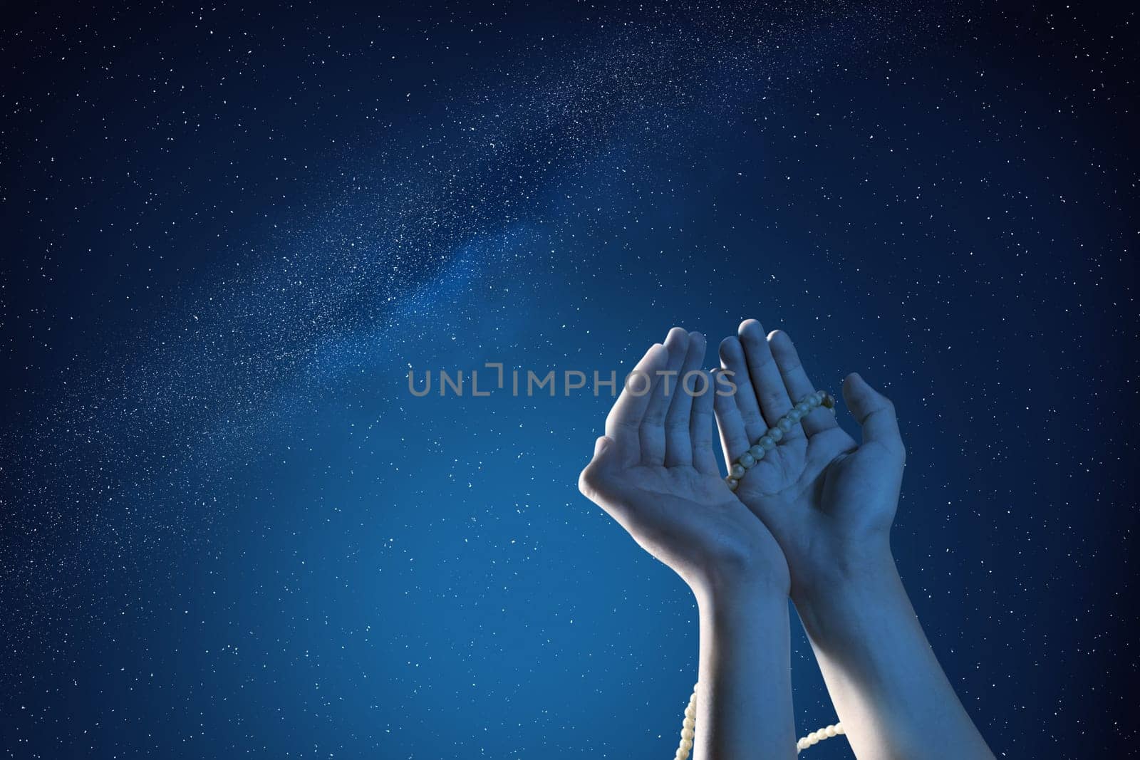 Muslim hands praying with prayer beads at outdoor with night scene background