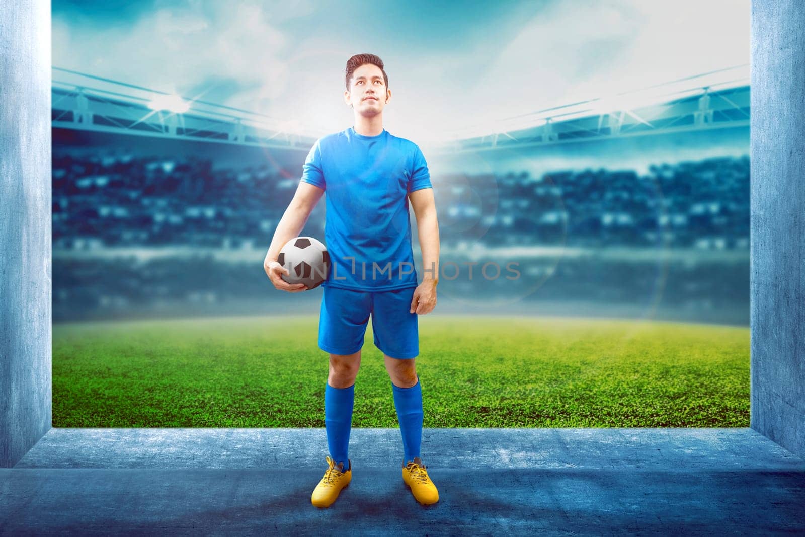 Asian football player man holding the ball in the stadium hallway before enter the field on stadium