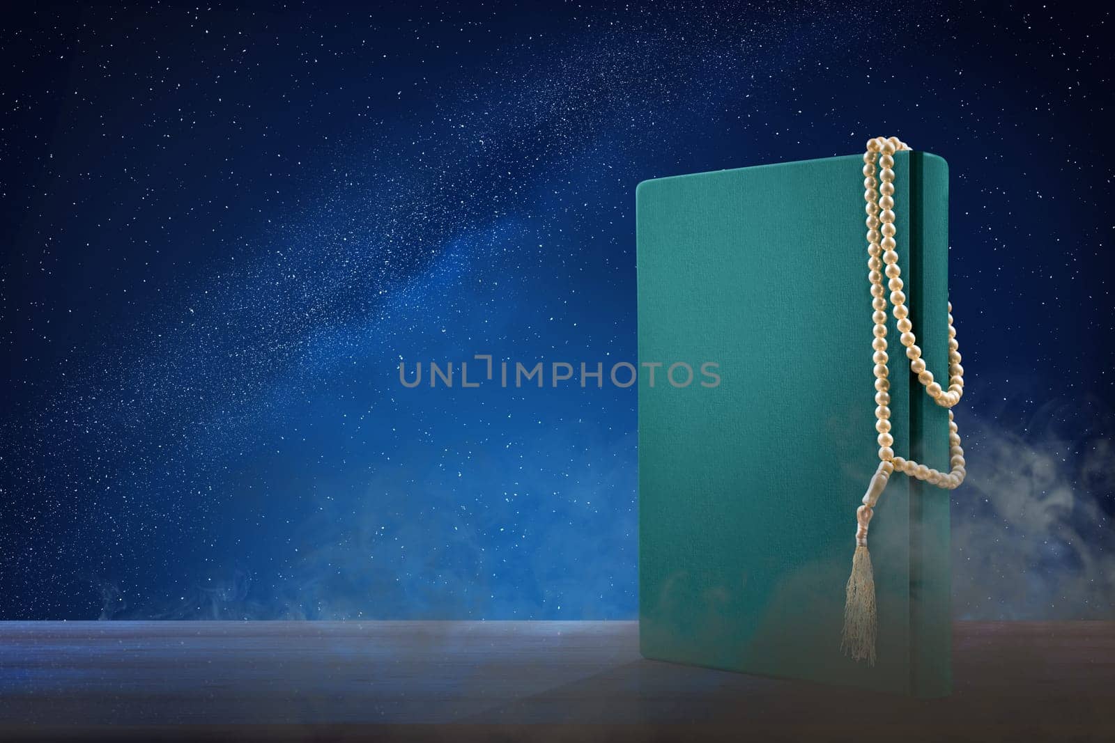 Quran and prayer beads on wooden table at outdoor with night scene background