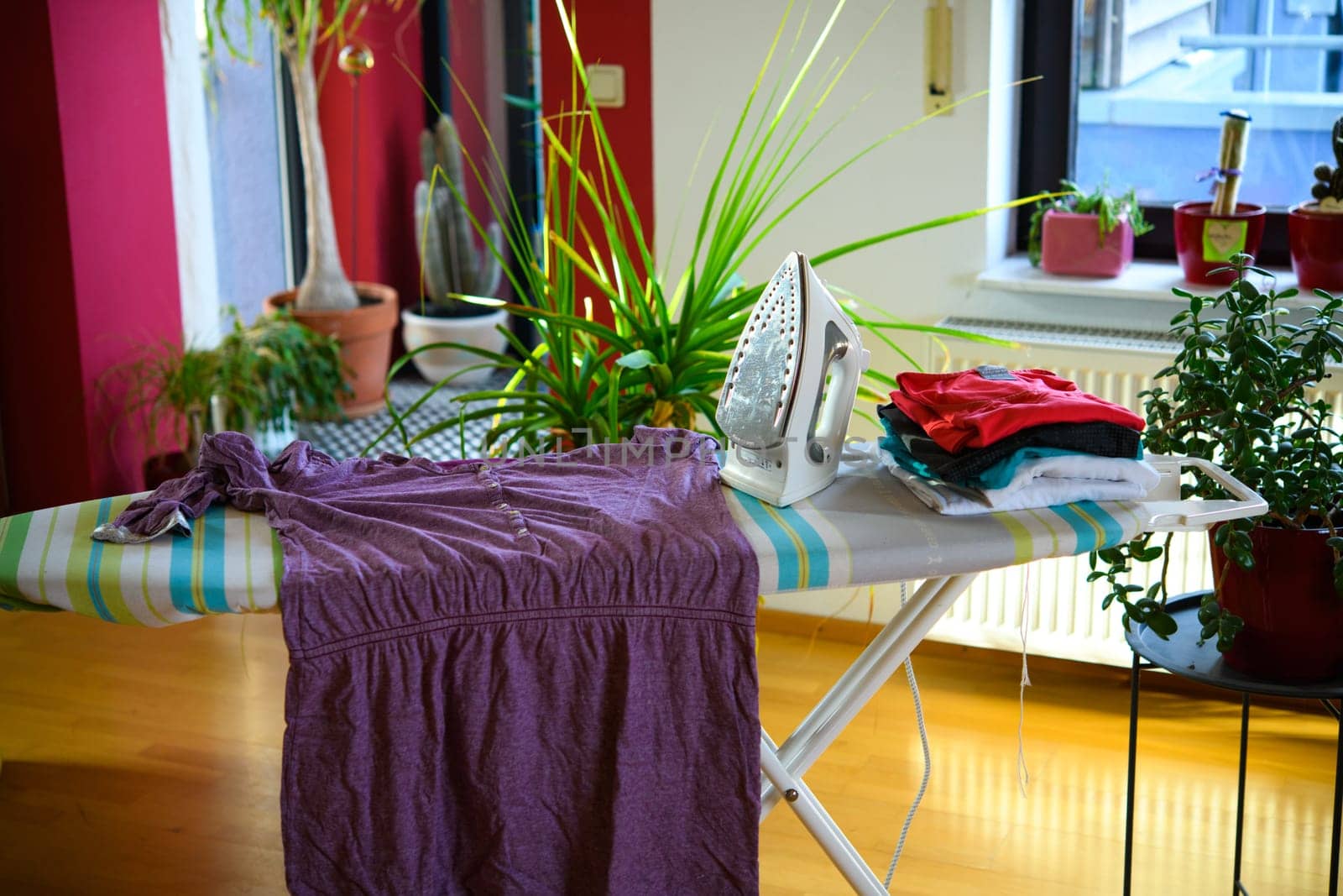 iron on ironing board with clothers in living room