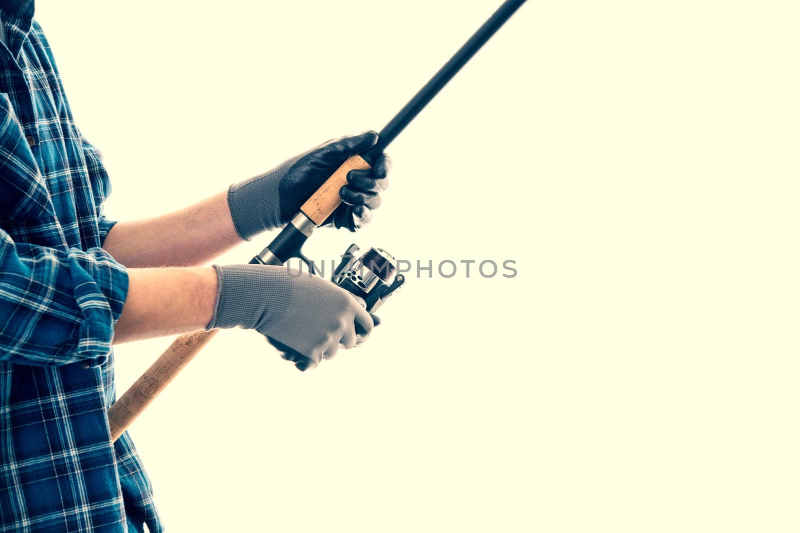 man with fishing rod and blue plaid shirt in front of white background