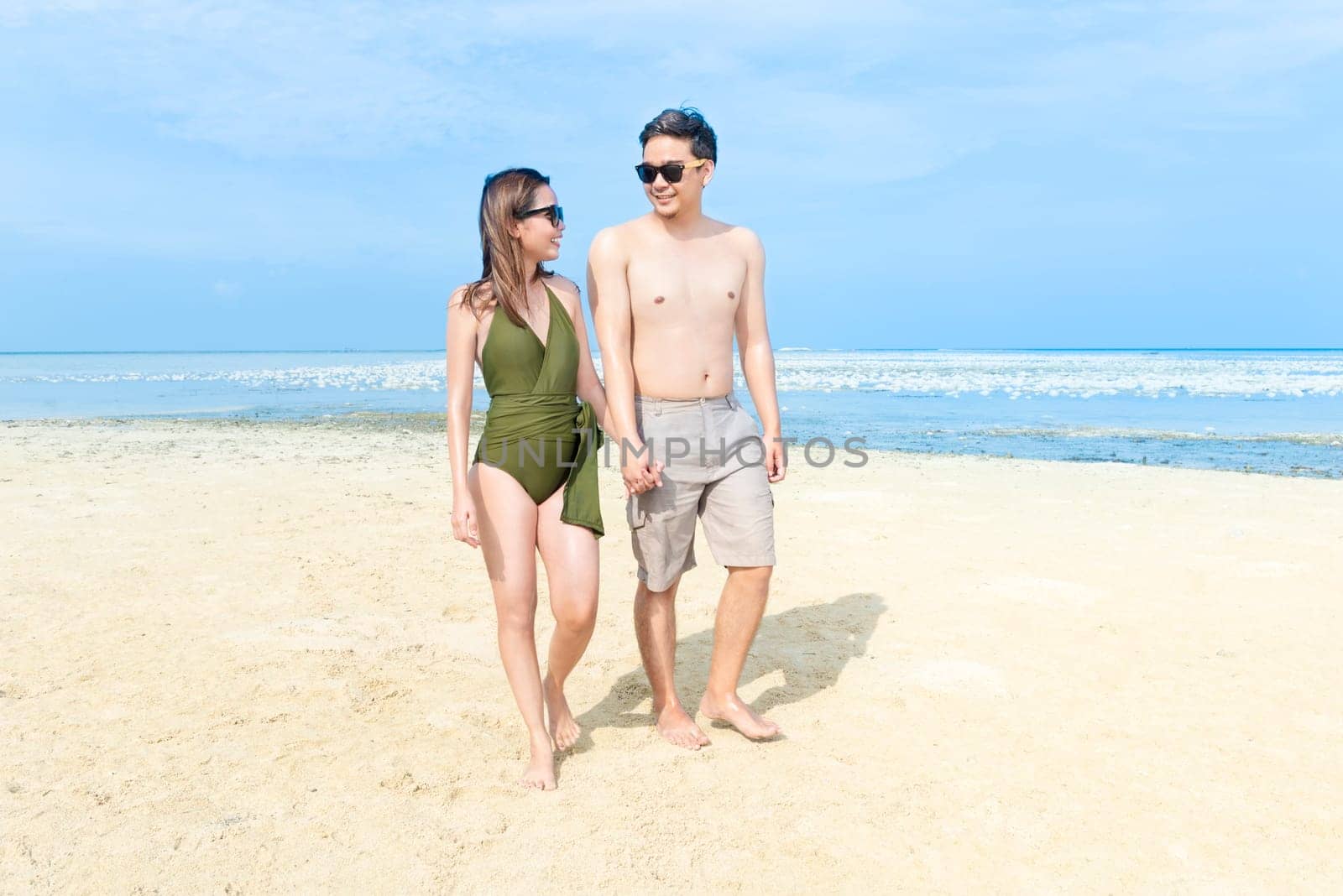 Asian romantic couple relax and walking on the beach. Summer vacation